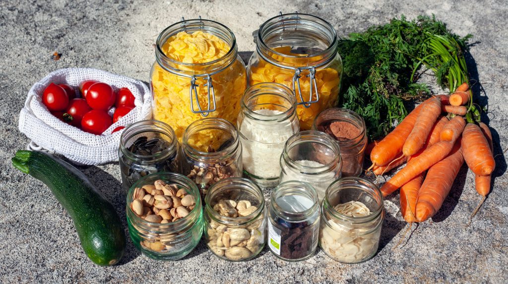 A selection of foods in reusable containers and loose vegetables - one way to reduce food waste.